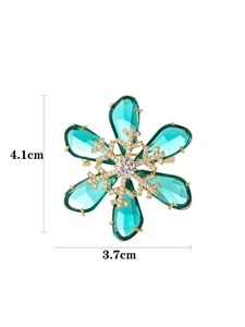 Detail shot of a rotating snowflake brooch with blue crystals measuring 4.1cm by 3.7cm