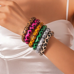 Detail view of 6-piece leopard print acrylic beaded stretch bracelets on a model's wrist