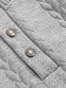 Macro detail of bronze metal buttons on grey quilted jacquard long sleeve henley shirt