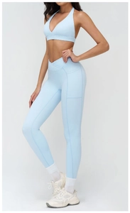 Detail of light blue high-waisted yoga leggings with crossover waistband and side pockets