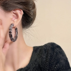 Gros plan de boucles d'oreilles créoles léopard en fausse fourrure pour l'automne