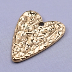 304 stainless steel gold heart pendant with hammered lava texture on purple fabric