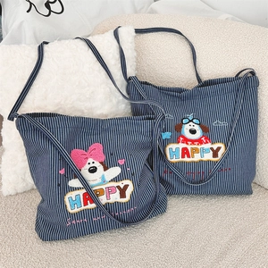 Detail of cartoon dog towel embroidery on striped canvas tote bag with happy lettering