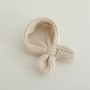 Close-up of cream ribbed knit baby scarf showing soft texture and cozy cross design
