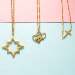 Three gold stainless steel necklaces with polar star, double heart, and cross pendants