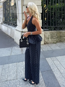 Détail d'un ensemble dos nu à pois avec un pantalon large en tissu fluide et élégant