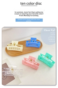 Collection of colorful candy-toned hollow square hair claws on a wooden tray