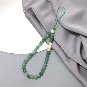 Detail of forest green beaded phone strap with white jade-like beads on silk
