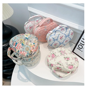 Group display of quilted heart makeup bags with floral patterns and soft fabric textures