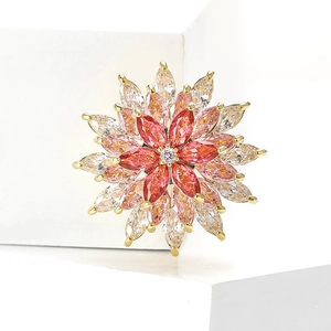 Rotating copper snowflake brooch with pink and red cubic zirconia on golden base