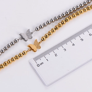 Detail view of double-layer beaded butterfly bracelet showing a 6mm bead size on ruler
