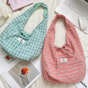 Detailed top view of plaid canvas tote bags with cute bow ties and brand labels
