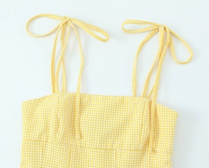 Detail des gelben Gingham-Tops mit verstellbaren Bindeträgern und feiner Stoffstruktur