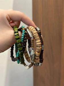Détail de bracelets bohèmes en perles de bois avec touches de turquoise et de tournesol