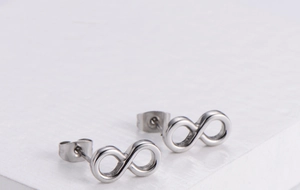 Detailed close-up of infinity shaped silver steel stud earrings on a white background