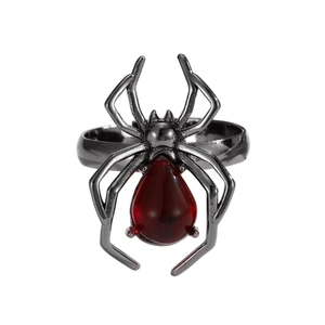 Vue détaillée d'une bague araignée punk avec pierre rouge et pattes en métal noir