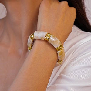 Close-up of marble texture beads and gold metal spacers on a stylish geometric bracelet