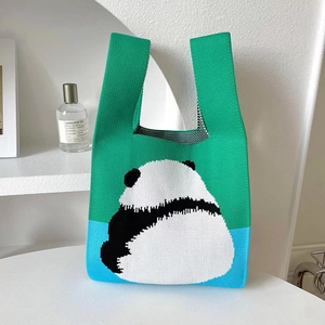 Detail of green and blue knitted tote bag with a cute panda pattern and woven texture