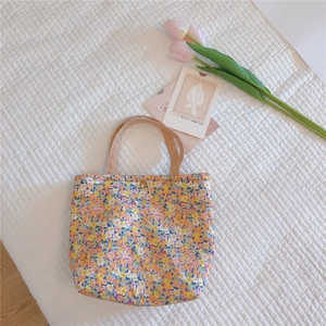 Close-up of floral bento bag with thick cotton fabric and vintage gold snap closure