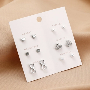 Detail of 6-pair stud earring set with pearls and silver hearts on pink card