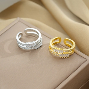 Elegant gold and silver zircon multi-row open rings displayed on a beige jewelry box