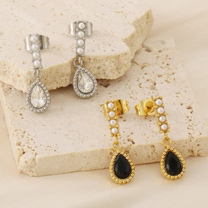 Détail des boucles d'oreilles gouttes d'eau dorées et argentées avec perles sur pierre