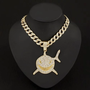 Détail du collier hip-hop avec pendentif requin serti de strass sur chaîne cubaine dorée