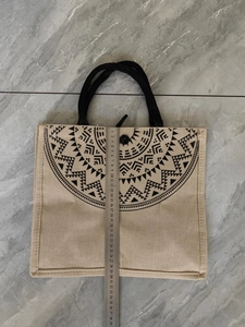 Detailed close-up of ethnic linen tote bag with mandala pattern and woven handles