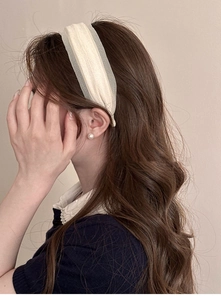 Detail view of cream wide tulle headband on long wavy hair with a soft texture