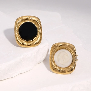 Detail of vintage 18k gold plated rings with black enamel and pearl white square texture