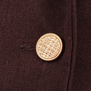 Close-up of golden vintage textured button on a chestnut brown tweed blazer jacket