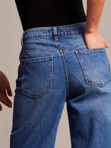 Jean en denim bleu vintage à taille haute avec jambes larges et détails des poches arrière