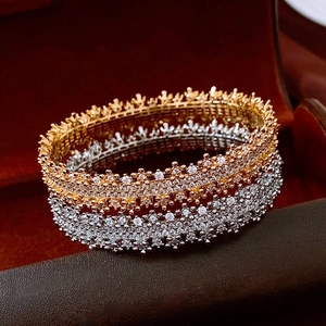 Close-up of 18k gold and silver plated bangles with zircons on a luxury jewelry box