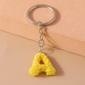 Macro detail of initial A keychain with yellow resin roses and silver metal ring