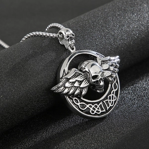 Detailed macro view of silver steel winged mummy skull pendant with Celtic knot ring