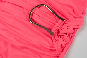 Close-up of coral knit dress detailing gathered fabric and gold U-shaped metal buckle