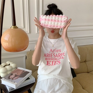 Detailed view of pink and white striped soft fabric pouch in a cozy lifestyle setting