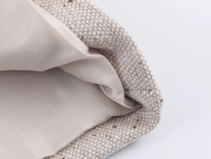 Vue détaillée de la texture tweed beige et de la doublure en satin champagne du blazer