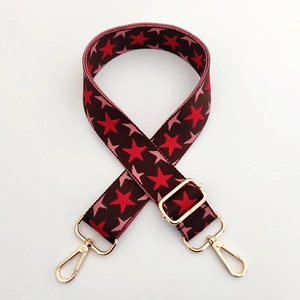Detail of adjustable star pattern woven bag strap with golden metal swivel hooks