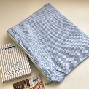 Detail shot of the blue and white gingham cosmetic bag with smooth zipper closure