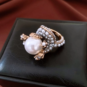 Detail of vintage flower ring with large central pearl on elegant black leather box