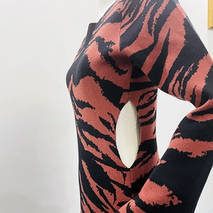 Vue détaillée du tricot à motif tigre rouge et noir avec découpe sur le côté