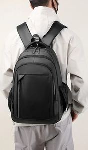 Rear view of a model wearing a large waterproof black laptop backpack for men and students