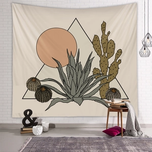 Detail view of a boho desert tapestry featuring cacti and sun on a white brick wall