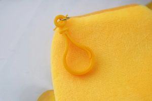 Close-up of yellow plush coin purse featuring a bright yellow plastic lobster clasp