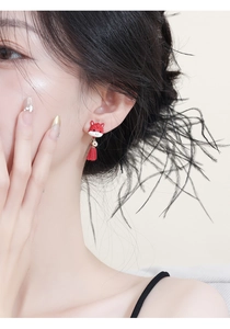 Close-up of New Chinese style red dragon earrings with gold coin and velvet tassels