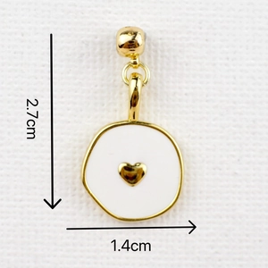 Detail view of heart pendant with white enamel and gold trim, size 2.7cm by 1.4cm