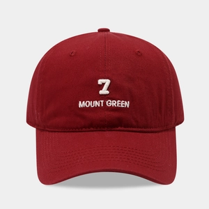 Detail van het witte borduursel met 7 en MOUNT GREEN op een bordeauxrode katoenen pet van top