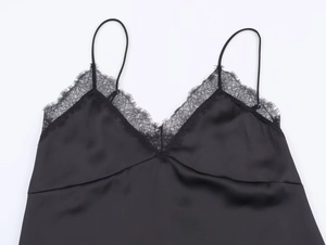 Close-up of black satin camisole featuring delicate lace trim and fine shoulder straps
