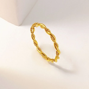 Minimalist gold twisted rope ring with a wavy polished finish in a premium lifestyle setting